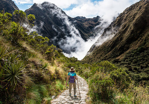 turista viendo paisaje en camino inca